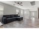 Bright living area with modern gray sofa, laminate floors, and stairway access at 106 Rock Crossing Ave, North Las Vegas, NV 89031