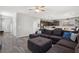 Open-concept living room with dark sectional sofa, connecting seamlessly to the modern kitchen and dining area at 106 Rock Crossing Ave, North Las Vegas, NV 89031