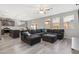 Open-concept living room with dark sectional sofa, connecting seamlessly to the modern kitchen and dining area at 106 Rock Crossing Ave, North Las Vegas, NV 89031