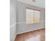 Bedroom featuring gray walls, hardwood floors, and natural light from a window with blinds at 10601 Lessona St, Las Vegas, NV 89141