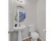 This half-bathroom features an oval mirror above a pedestal sink and a standard toilet at 10601 Lessona St, Las Vegas, NV 89141