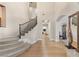 Elegant foyer with a curved staircase, hardwood floors, and arched entrances creating a grand entrance at 11680 Evergreen Creek Ln, Las Vegas, NV 89135