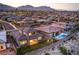 A dusk view of a home with a pool in a community with mountain views at 12295 Skyracer Dr, Las Vegas, NV 89138