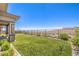 A manicured backyard with a lush lawn and a wrought iron fence providing safety and unobstructed scenic mountain views at 12295 Skyracer Dr, Las Vegas, NV 89138