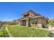 Beautiful backyard with a lush green lawn, landscaped yard and wrought iron fence, and covered patio of a modern home at 12295 Skyracer Dr, Las Vegas, NV 89138
