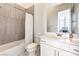 Well-lit bathroom with white vanity, combination shower and tub with tile surround at 12295 Skyracer Dr, Las Vegas, NV 89138