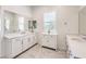 Bathroom featuring double sinks, white cabinets, large mirror and marble tile flooring at 12295 Skyracer Dr, Las Vegas, NV 89138