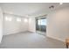 Bright bedroom with neutral carpet, natural light from three windows, and a sliding glass door to the balcony at 12295 Skyracer Dr, Las Vegas, NV 89138