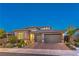 Attractive single-story home at dusk with a two-car garage, desert landscaping, and modern design at 12295 Skyracer Dr, Las Vegas, NV 89138