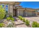 Charming single-story home with a two-car garage, desert landscaping, and a brick-paved driveway at 12295 Skyracer Dr, Las Vegas, NV 89138