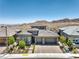 An elegant home featuring a paved driveway, three-car garage, well-manicured landscaping and mountain views in the distance at 12295 Skyracer Dr, Las Vegas, NV 89138