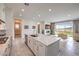 Open concept kitchen with island and view of the living room and sliding glass doors to the back yard at 12295 Skyracer Dr, Las Vegas, NV 89138