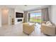 Bright living room with fireplace, comfortable seating, large sliding glass doors and elegant drapes at 12295 Skyracer Dr, Las Vegas, NV 89138