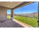 A covered patio with brick pavers overlooks a manicured lawn and a wrought iron fence offering scenic views at 12295 Skyracer Dr, Las Vegas, NV 89138