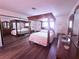 Elegant primary bedroom with a four-poster bed, wood floors, and mirrored closet at 1320 Driscoll Dr # 201, Las Vegas, NV 89128