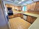 Kitchen featuring white appliances, oak cabinetry and retro flooring at 1400 Silver Peak Ave, Pahrump, NV 89048