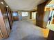 Open living room with wood paneled walls and access to kitchen at 1400 Silver Peak Ave, Pahrump, NV 89048
