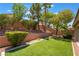 Backyard featuring low maintenance artificial turf, mature trees and shrubbery at 1789 Castro Hill Ave, Henderson, NV 89012
