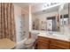 Bright bathroom featuring a tub with shower, large mirror, and wooden vanity providing style and functionality at 1789 Castro Hill Ave, Henderson, NV 89012
