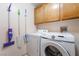Efficient laundry area with modern washer and dryer, complemented by wooden cabinets for organized storage at 1789 Castro Hill Ave, Henderson, NV 89012