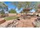 Amazing backyard featuring stone accents, artificial turf, a mature tree, and custom built pergola at 1795 Nuevo Rd, Henderson, NV 89014