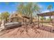 Expansive backyard featuring a hot tub, covered patio, artificial turf, and beautiful mature tree at 1795 Nuevo Rd, Henderson, NV 89014