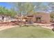 Large backyard featuring a covered patio, built-in seating, artificial turf, and mature tree at 1795 Nuevo Rd, Henderson, NV 89014