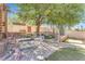 Backyard with a multi-level patio and lush lawn, shaded by mature trees, perfect for relaxation at 1795 Nuevo Rd, Henderson, NV 89014
