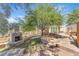 Outdoor stone fireplace and mature trees in a spacious backyard, perfect for entertaining at 1795 Nuevo Rd, Henderson, NV 89014