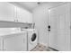 Functional laundry room with washer, dryer, and ample storage cabinets at 1795 Nuevo Rd, Henderson, NV 89014