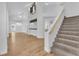 Bright living room boasting vaulted ceilings, and staircase with plush carpet, with wood flooring throughout main area at 1795 Nuevo Rd, Henderson, NV 89014