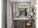 Bathroom with gray cabinets, single sink, large mirror, tiled shower with gray curtains and stool at 2200 S Fort Apache Rd # 2041, Las Vegas, NV 89117
