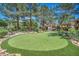 Community putting green featuring synthetic turf, mature trees, and surrounding landscaping at 2200 S Fort Apache Rd # 2041, Las Vegas, NV 89117