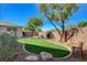 Charming backyard with artificial grass, mature trees, rock features, and a peaceful seating area at 2333 Indigo Island St, Henderson, NV 89044