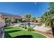 Beautifully landscaped backyard with a pool, spa, outdoor kitchen, and mature trees at 2333 Indigo Island St, Henderson, NV 89044