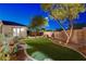 Landscaped backyard with manicured lawn, mature trees, and ambient lighting at 2333 Indigo Island St, Henderson, NV 89044