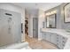 Contemporary bathroom showcasing a walk-in shower, gray vanity, and walk-in closet with lots of storage space at 2333 Indigo Island St, Henderson, NV 89044