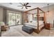 Serene main bedroom with a four-poster bed, sitting area, and large windows overlooking the backyard at 2333 Indigo Island St, Henderson, NV 89044