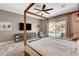 Tranquil main bedroom with a four-poster bed, sitting area, and views of the backyard pool area at 2333 Indigo Island St, Henderson, NV 89044
