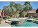 Beautiful pool and spa with waterfall feature surrounded by lush landscaping and mature trees at 2333 Indigo Island St, Henderson, NV 89044