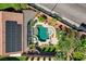 Aerial view of a backyard pool with hot tub, lush landscaping, patio, and solar panels at 2333 Indigo Island St, Henderson, NV 89044