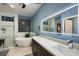 Bright bathroom featuring a soaking tub, dual sink vanity, and a glass-enclosed shower at 2786 Scotts Valley Dr, Henderson, NV 89052