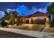 Well-lit home exterior featuring a three-car garage, desert landscaping, and tiled roof at 2786 Scotts Valley Dr, Henderson, NV 89052
