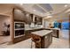 Modern kitchen featuring dark cabinets, stainless steel appliances, an island and tile flooring at 2786 Scotts Valley Dr, Henderson, NV 89052