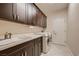 Updated laundry room with a sink, dark cabinets, and modern washer and dryer units at 2786 Scotts Valley Dr, Henderson, NV 89052