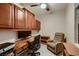 A dedicated office space with built in cabinets, a ceiling fan and a comfortable recliner at 2786 Scotts Valley Dr, Henderson, NV 89052