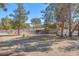 Equestrian property featuring a horse paddock, shelter, white fencing, and mature trees, perfect for horse lovers at 2868 Vista Del Sol Ave, Las Vegas, NV 89120