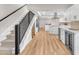 Modern kitchen featuring sleek white cabinetry, stainless steel appliances, and a staircase with black metal railings at 2868 Vista Del Sol Ave, Las Vegas, NV 89120