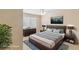 Staged main bedroom with a bed, dresser, nightstands, lamps, ceiling fan and a TV at 3129 White Rose Way, Henderson, NV 89014