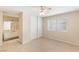 Bedroom with neutral colors, tile flooring, ceiling fan, and access to an ensuite bathroom at 3129 White Rose Way, Henderson, NV 89014